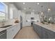Bright kitchen features white cabinetry, stainless appliances, and a gray island with marble countertops and pendant lighting at 8108 Wild Blue Ter, Sarasota, FL 34241