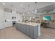 Spacious island with gray cabinetry, marble countertops, and pendant lights, connecting to the living and dining areas at 8108 Wild Blue Ter, Sarasota, FL 34241