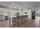 Well-lit kitchen with white cabinetry, stainless steel appliances, a large island with bar seating, and modern pendant lighting at 8108 Wild Blue Ter, Sarasota, FL 34241