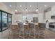 Bright kitchen features white cabinetry, stainless steel appliances, pendant lighting, and a large island with bar seating at 8108 Wild Blue Ter, Sarasota, FL 34241