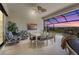Evening view of a lanai with a dining area and comfortable seating, perfect for enjoying the sunset at 8108 Wild Blue Ter, Sarasota, FL 34241