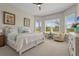 Bright main bedroom featuring a ceiling fan, two chairs by the windows, and soft, neutral decor at 8108 Wild Blue Ter, Sarasota, FL 34241