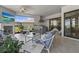 An inviting covered lanai features a full outdoor kitchen, comfortable seating, and a beautiful view of the yard at 8108 Wild Blue Ter, Sarasota, FL 34241