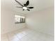 A bright bedroom with white tile floors, a ceiling fan, and a window with blinds at 835 S Osprey Ave # 101, Sarasota, FL 34236