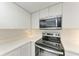 Close up of updated kitchen featuring stainless steel oven, microwave, and white cabinets at 835 S Osprey Ave # 101, Sarasota, FL 34236