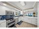 Bright kitchen features white cabinets, stainless appliances, and an open-concept layout with water views at 101 Sunset Dr # 103, Sarasota, FL 34236
