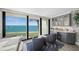 Bright waterfront living room features floor-to-ceiling windows, built in wet bar and casual seating at 101 Sunset Dr # 103, Sarasota, FL 34236