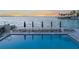 Inviting waterfront pool deck featuring lounge chairs, umbrellas, and tranquil bay views at 101 Sunset Dr # 103, Sarasota, FL 34236