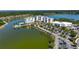 An aerial view showcases the building and its waterfront location with palm trees and parking at 10530 Boardwalk Loop # 201, Lakewood Ranch, FL 34202