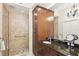 Bright bathroom with marble counters, wood cabinets, and glass shower with tan tile at 10530 Boardwalk Loop # 201, Lakewood Ranch, FL 34202