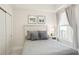 This bedroom features neutral tones, complemented by a plush bed and natural light from the window at 10530 Boardwalk Loop # 201, Lakewood Ranch, FL 34202