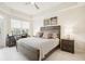 Comfortable bedroom featuring a large window, waterfront views, soft lighting, and neutral decor at 10530 Boardwalk Loop # 201, Lakewood Ranch, FL 34202