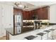 The kitchen features stainless steel appliances and dark brown cabinetry with a breakfast bar and bar stools at 10530 Boardwalk Loop # 201, Lakewood Ranch, FL 34202