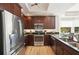 This kitchen features stainless appliances, dark wood cabinets and drawers, recessed lighting and granite counter tops at 10530 Boardwalk Loop # 201, Lakewood Ranch, FL 34202