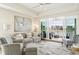A bright, airy living room with water views, ceiling fan, and stylish furnishings with a sliding glass door to the outside deck at 10530 Boardwalk Loop # 201, Lakewood Ranch, FL 34202