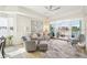 A bright, airy living room with water views, ceiling fan, and stylish furnishings with a sliding glass door to the outside deck at 10530 Boardwalk Loop # 201, Lakewood Ranch, FL 34202