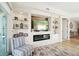 A stylish living room boasts custom shelving, a modern fireplace, and a comfortable chair with a sliding glass door to the outside deck at 10530 Boardwalk Loop # 201, Lakewood Ranch, FL 34202