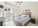 Bright main bedroom with modern decor, a wooden bed frame and floor to ceiling curtains at 10530 Boardwalk Loop # 201, Lakewood Ranch, FL 34202
