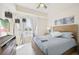 Light-filled main bedroom features a wooden bed frame, dresser and white tile flooring at 10530 Boardwalk Loop # 201, Lakewood Ranch, FL 34202
