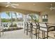 A shaded outdoor bar area with barstools and views of the lake and lush greenery at 10530 Boardwalk Loop # 201, Lakewood Ranch, FL 34202