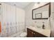Cozy bathroom with a dark wood vanity and a shower with decorative shower curtain at 108 21St Ne St, Bradenton, FL 34208