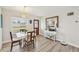 Bright dining room features new floors, white table, and decorative front door at 108 21St Ne St, Bradenton, FL 34208