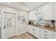 Bright kitchen with white cabinets, granite countertops, stainless steel sink, and modern appliances at 108 21St Ne St, Bradenton, FL 34208