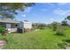 Expansive backyard with firewood storage, garden, green grass, and lake view on a sunny day at 1208 Angela Maria Rd, Sarasota, FL 34243