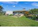 Lush backyard with vegetable garden, green grass, shed, landscaping, and mature trees on a sunny day at 1208 Angela Maria Rd, Sarasota, FL 34243