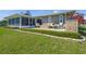 The lush backyard features a paved patio, outdoor seating, grill, and a screened in porch at 1208 Angela Maria Rd, Sarasota, FL 34243