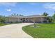 A beautiful single-story home featuring a well-manicured lawn and a winding driveway at 1208 Angela Maria Rd, Sarasota, FL 34243