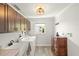 Well-lit laundry room with wooden cabinets, sink, washer, dryer, and a window providing natural light at 1208 Angela Maria Rd, Sarasota, FL 34243
