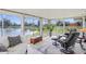 Bright sun room featuring waterfront views, tile floors, comfortable seating, and an abundance of natural light at 1208 Angela Maria Rd, Sarasota, FL 34243