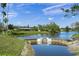 Stunning water view of the house with palm trees and lush landscaping at 1208 Angela Maria Rd, Sarasota, FL 34243