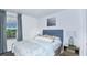 Calming bedroom with a blue upholstered headboard, soft lighting, and a serene window view at 15112 Cuzcorro Ct, Nokomis, FL 34275