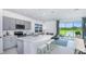 Open kitchen has an island, stainless appliances, and a view of the water at 15112 Cuzcorro Ct, Nokomis, FL 34275