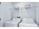 Bright laundry room with white washer and dryer set, complemented by wire shelving at 15112 Cuzcorro Ct, Nokomis, FL 34275