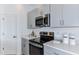 Contemporary kitchen with stainless steel appliances, gray cabinetry, and sleek countertops at 15132 Cuzcorro Ct, Nokomis, FL 34275