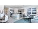 Modern open-concept kitchen with stainless steel appliances, a breakfast bar, and an adjacent living area at 15132 Cuzcorro Ct, Nokomis, FL 34275