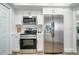 Modern kitchen featuring stainless steel appliances, white cabinetry, and stone countertops at 1606 Jim Jim Ct, Venice, FL 34293