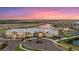 Aerial view of the clubhouse surrounded by palm trees and meticulously landscaped grounds at 16455 Whale Grey Pl, Bradenton, FL 34211