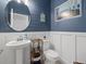 Coastal-themed half bath with a pedestal sink, wainscoting, and nautical decorations at 16455 Whale Grey Pl, Bradenton, FL 34211