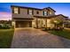 Charming two-story home with a well-manicured lawn, brick-paved driveway, and a two-car garage, enhancing curb appeal at 16455 Whale Grey Pl, Bradenton, FL 34211