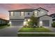 A beautiful two-story home at dusk featuring a spacious three-car garage and manicured lawn at 16455 Whale Grey Pl, Bradenton, FL 34211