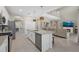 Bright kitchen featuring white cabinets, a center island with seating, and a view into the living room at 16455 Whale Grey Pl, Bradenton, FL 34211