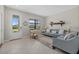 Comfortable living room features neutral tones, a decorative shelf, and a view of the front yard, creating a cozy atmosphere at 16455 Whale Grey Pl, Bradenton, FL 34211