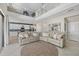Open-concept living room with a sectional sofa, round rug, and views into the kitchen with an eat-in island at 16455 Whale Grey Pl, Bradenton, FL 34211