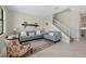 Comfortable living room features neutral tones, a decorative shelf, and a view of the staircase, creating a cozy atmosphere at 16455 Whale Grey Pl, Bradenton, FL 34211