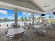 Outdoor seating area with tables, chairs, and views of the pool and palm trees at 16455 Whale Grey Pl, Bradenton, FL 34211