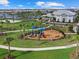 A vibrant playground features swings and slides, framed by manicured lawns and palm trees at 16455 Whale Grey Pl, Bradenton, FL 34211